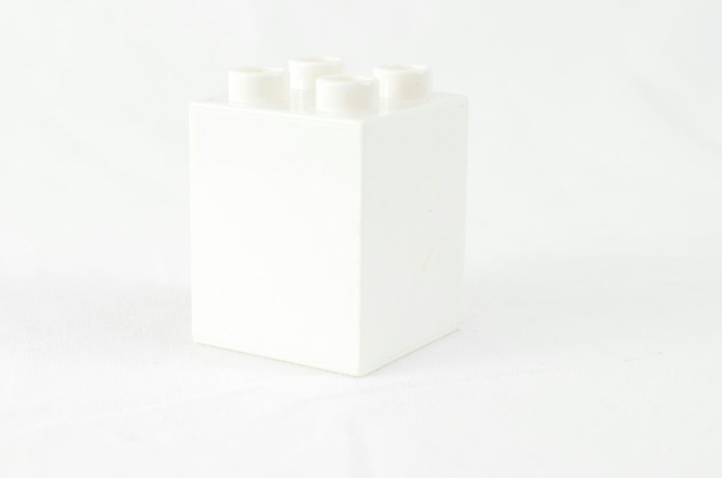 a white box with four white candles in it