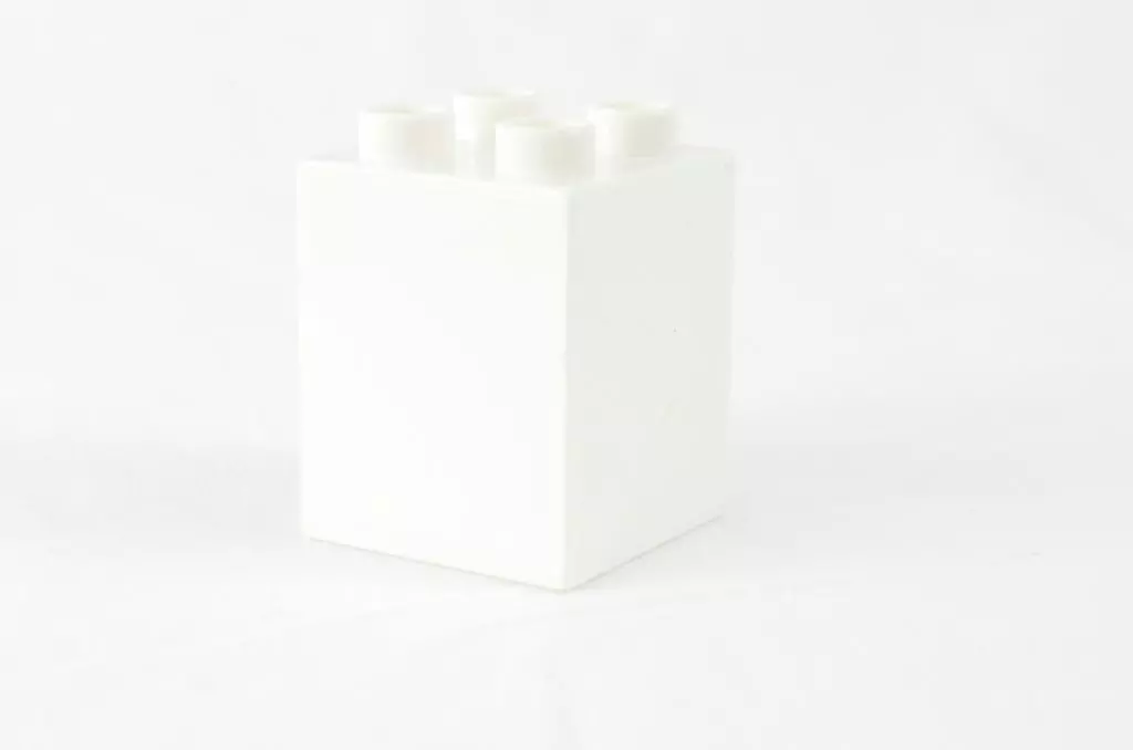a white box with four white candles in it